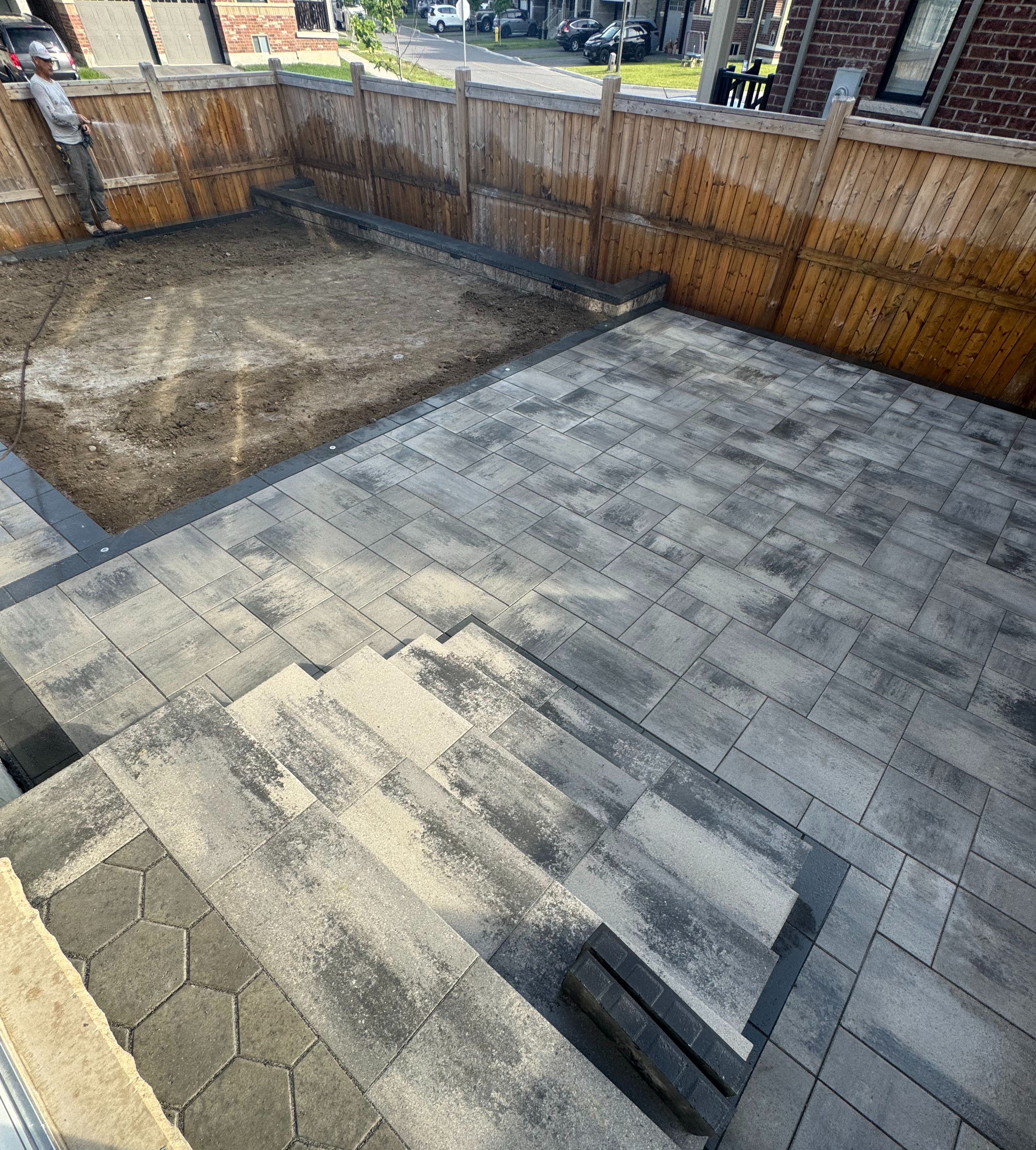 Backyard interlock in progress — multi-level layout with steps