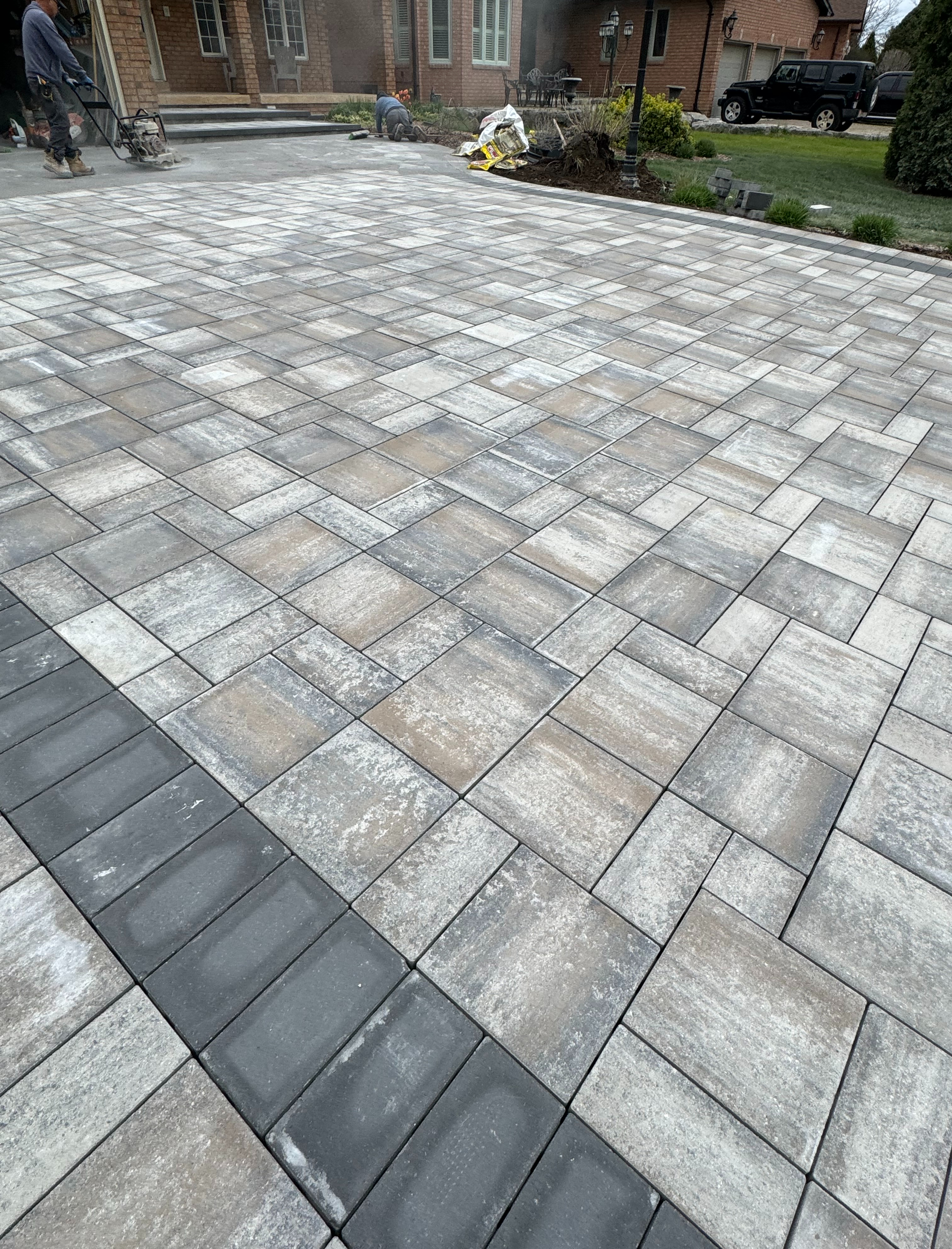 Interlock driveway installation — multi-tone herringbone pattern